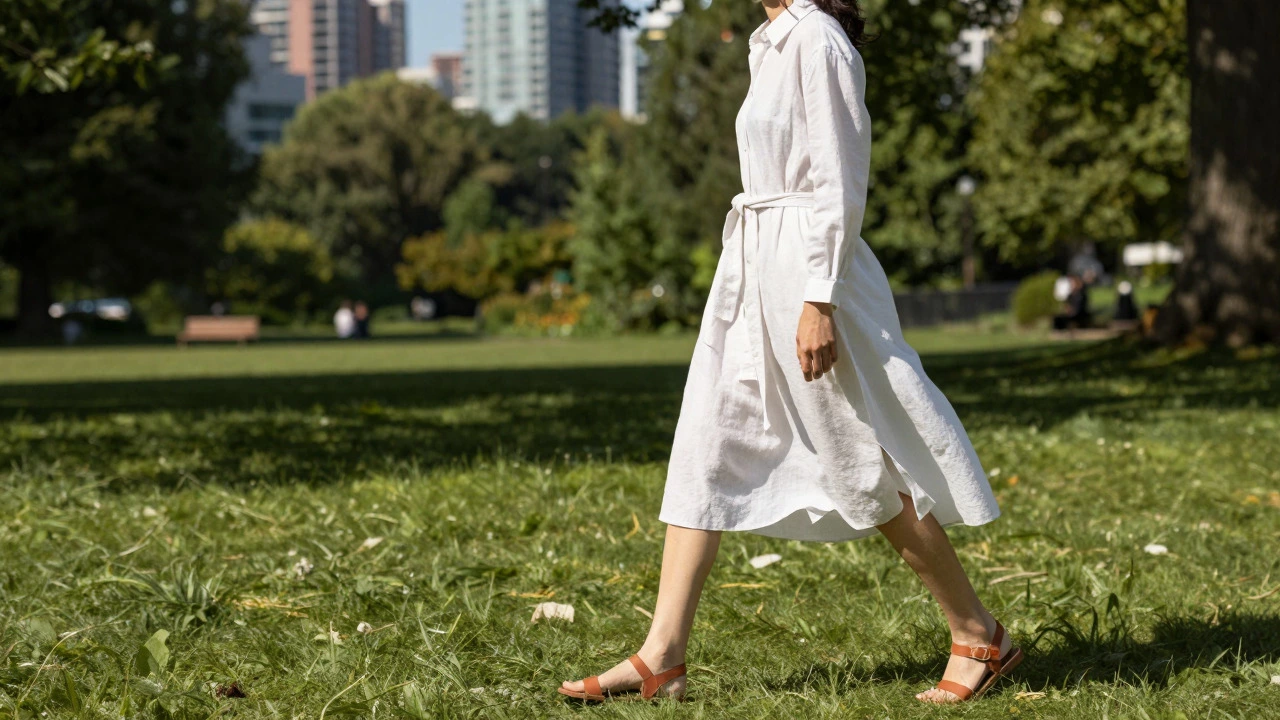 Woman in a white shirt dress with a linen jacket tied at waist